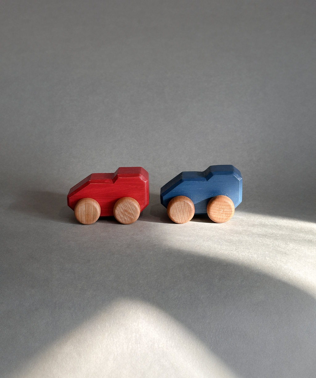 Red and blue Mono wooden cars shown together; each sold separately