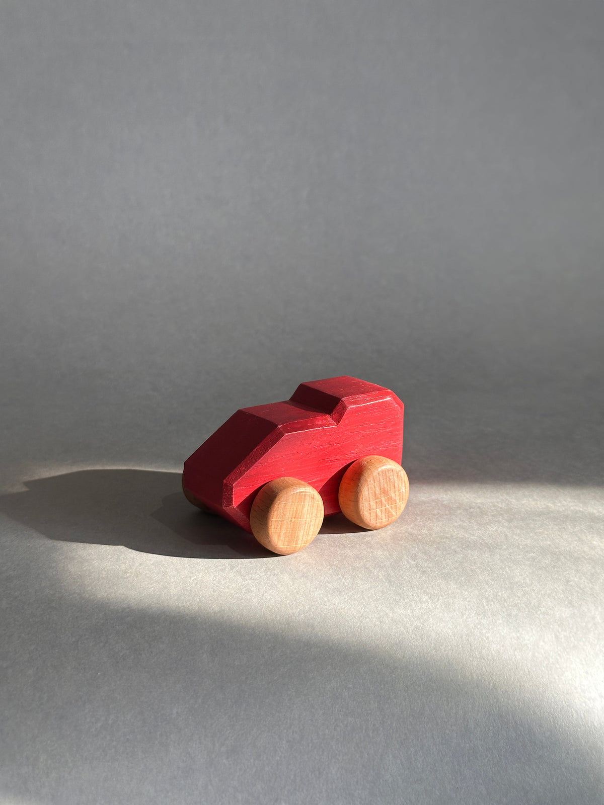 Red Mono wooden car in warm natural daylight